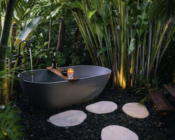 A grey outdoor bath in palm tree garden